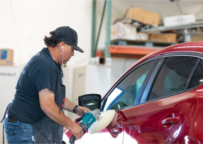 Buffing a finish on a Mazda auto body repair