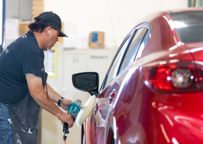 Buffing a finish on a Mazda auto body repair