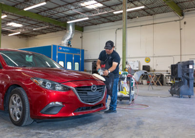 Buffing a finish on a Mazda auto body repair