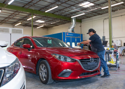 Buffing a finish on a Mazda auto body repair