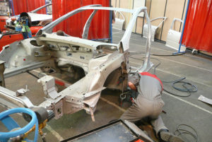 Coachbuilding - Mechanic Working on Car Framework