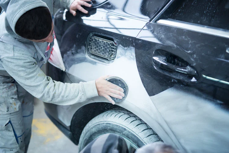 mechanic repairing scratches with a sandpaper